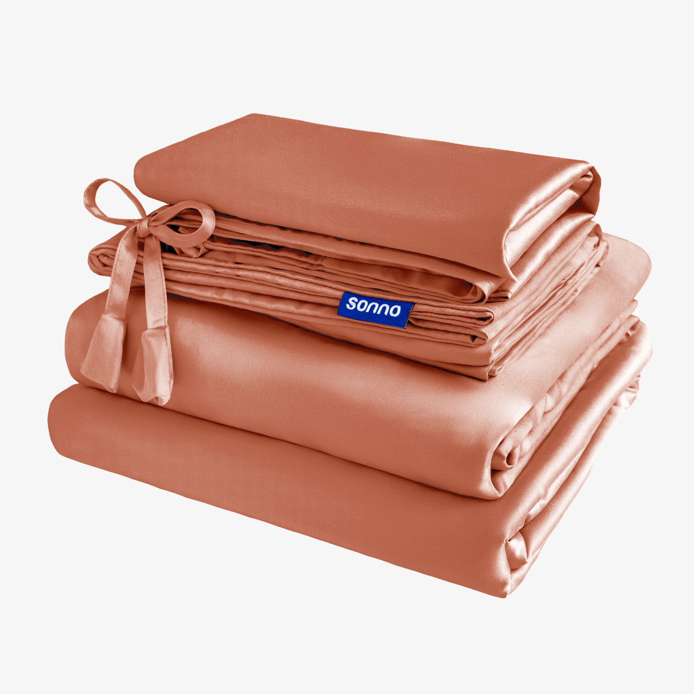 Folded peach-colored bed sheets with a ribbon and 'sonno' label on a white background