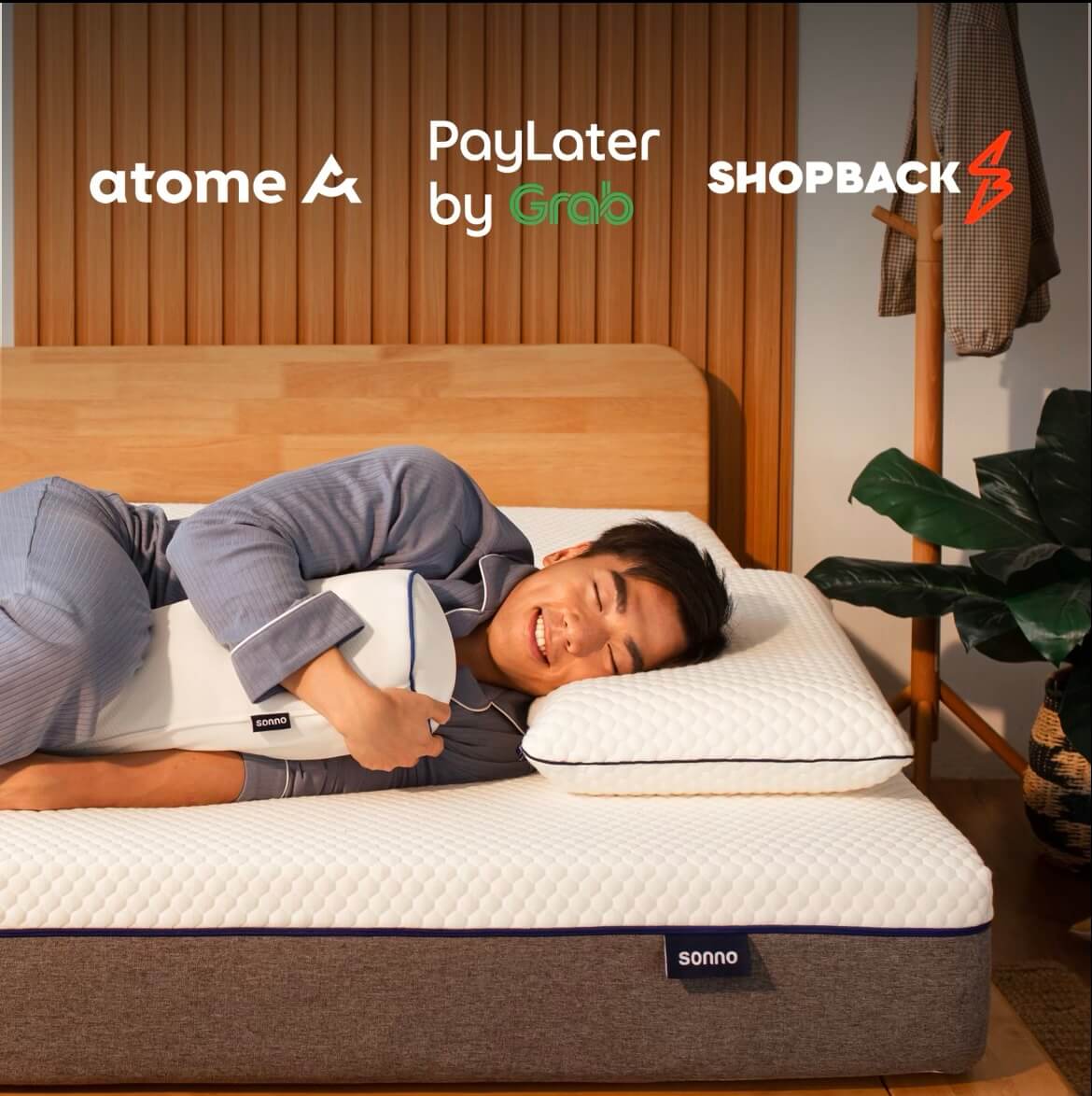 Person lying on a Sonno mattress with branding for atome, PayLater by Grab, and Shopback.