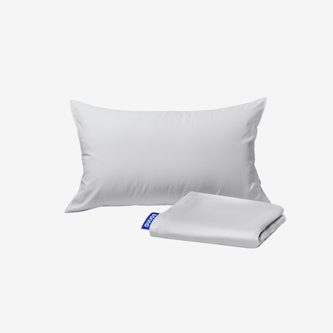 White pillow and folded white sheet on a light gray background