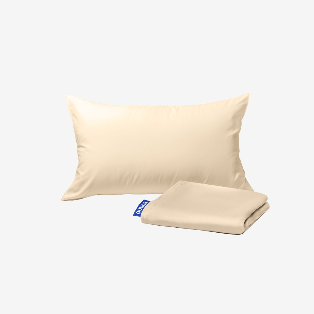Beige pillow and fitted sheet set on a white background