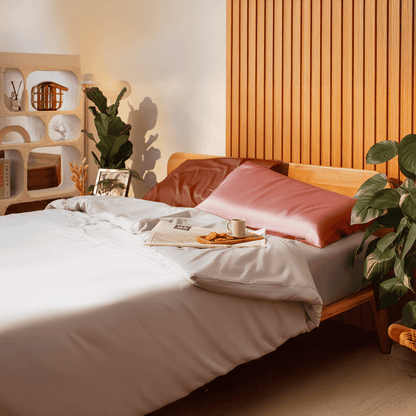 Bedroom with a wooden bed, pink pillows, and a small table with a cup and cookies.