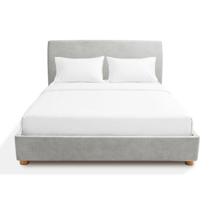 Gray Sonno divan bed frame upholstered with white bedding on a white background